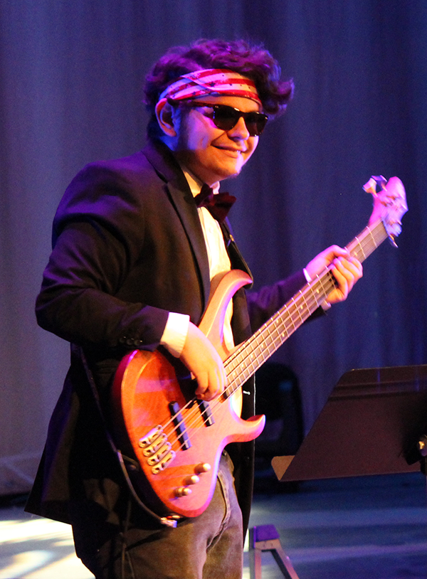 A student musician plays guitar at a concert